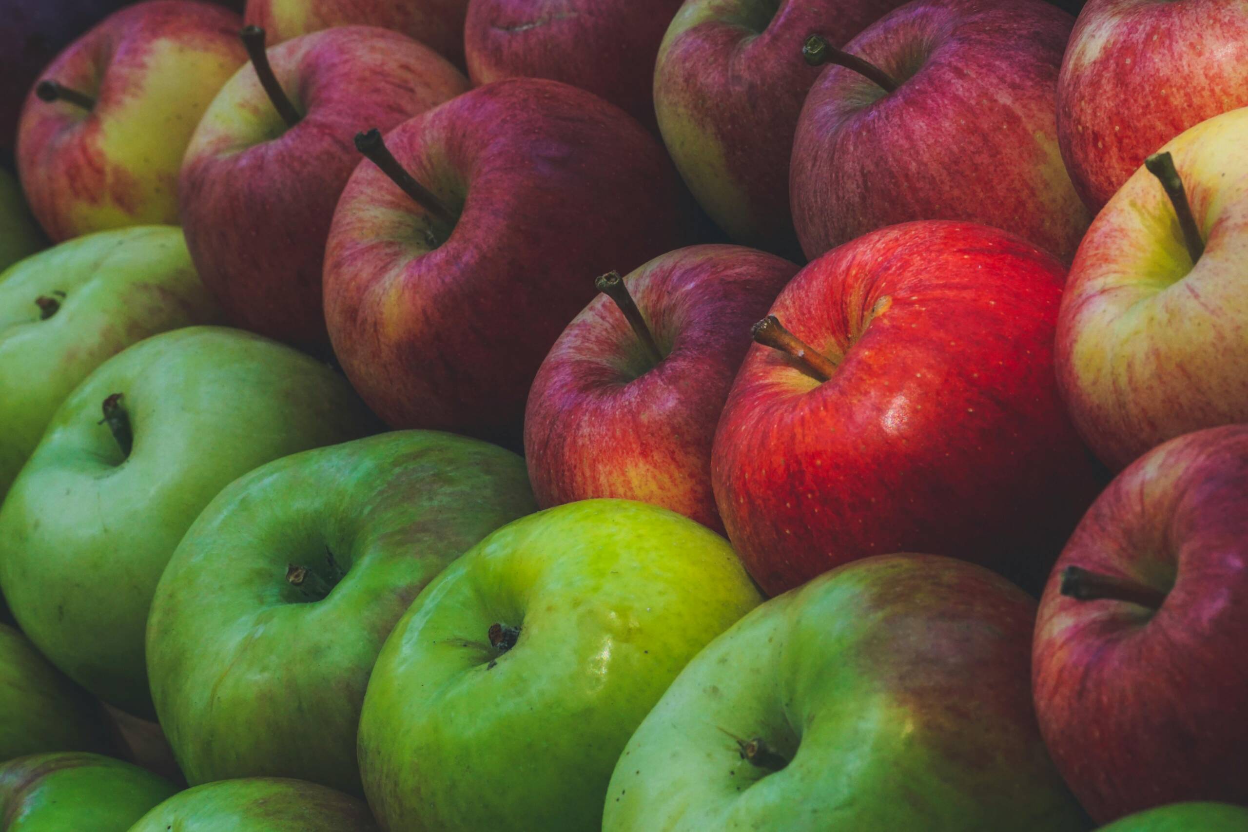 A vibrant pile of fresh red and green apples showcasing their natural color and texture.