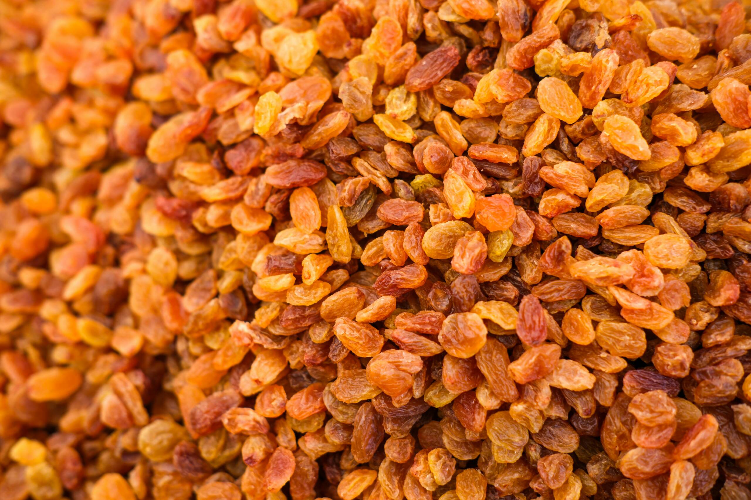 Top view of a heap of dried golden raisins, perfect for culinary and healthy eating visuals.